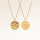 Personalized round gold necklace with rippled wave surface and space for engraving of text, coordinates or handwriting on the back