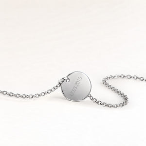 Dos d'un collier rond en argent avec une date gravée personnalisée
