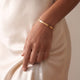 Mannequin portant un bracelet jonc personnalisé en or avec espace pour graver un texte ou des coordonnées