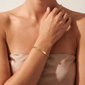 Model wearing personalized bar gold bracelet for women with space for engraving of text or coordinates