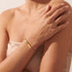Mannequin portant un bracelet barre en or pour femme gravé d'initiales et d'un petit cœur