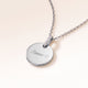 Collier rond en argent avec zircons vu de côté avec un prénom et un cœur gravés