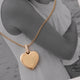 Heart-shaped gold necklace with personalized engraving of handwriting or drawing on the front and back