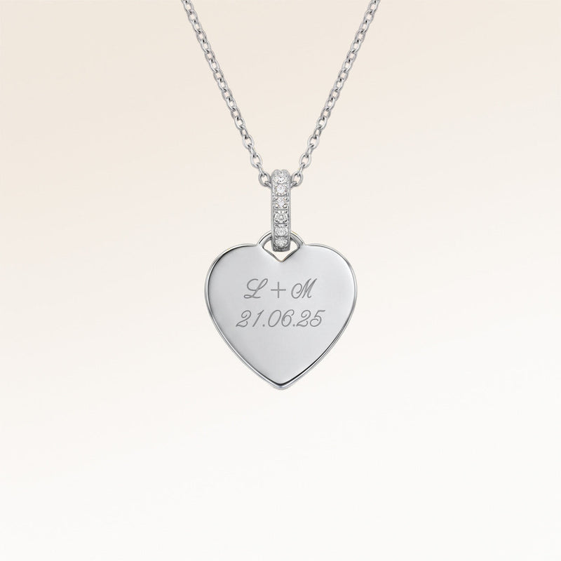 Gros plan du pendentif cœur minimaliste en argent avec zircons blancs et espace pour gravure personnalisée sur le devant et au dos