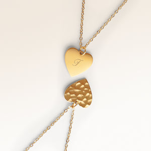 Close-up of minimalist heart-shaped heart pendant in gold with rippled wave surface and space for engraving on back
