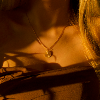 Collier rond personnalisé en or avec motif rayonnant strié et espace pour gravure de texte, coordonnées ou écriture manuscrite au dos