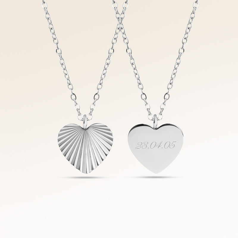 Personalized heart-shaped silver necklace with ribbed sunburst pattern and space for engraving of text, coordinates or handwriting on the back