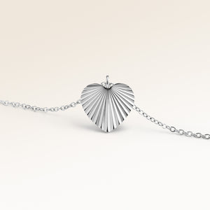 Personalized heart-shaped silver necklace with ribbed sunburst pattern and space for engraving of text, coordinates or handwriting on the back