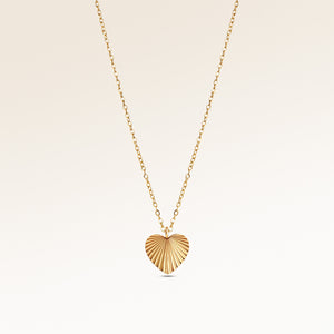 Personalized heart-shaped gold necklace with ribbed sunburst pattern centered and minimalist pendant with space for engraving on back.