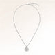Full round silver necklace laid out flat with a fine adjustable silver chain and a minimalist round pendant for personal engraving